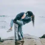 Verliebtes junges Paar am Meer. Spielerisch, während er sie küsst