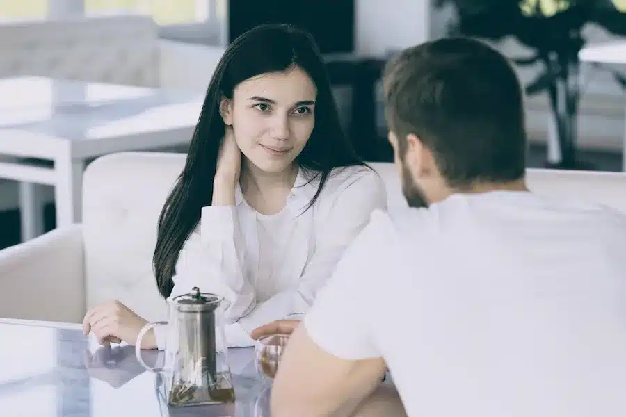 Frau erklärt ihrem Partner ihre Bedürfnisse und neue Grenzen als Teil von Selbstfürsorge in der Beziehung