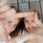 Young beautiful couple smiling, lying on wooden boards.