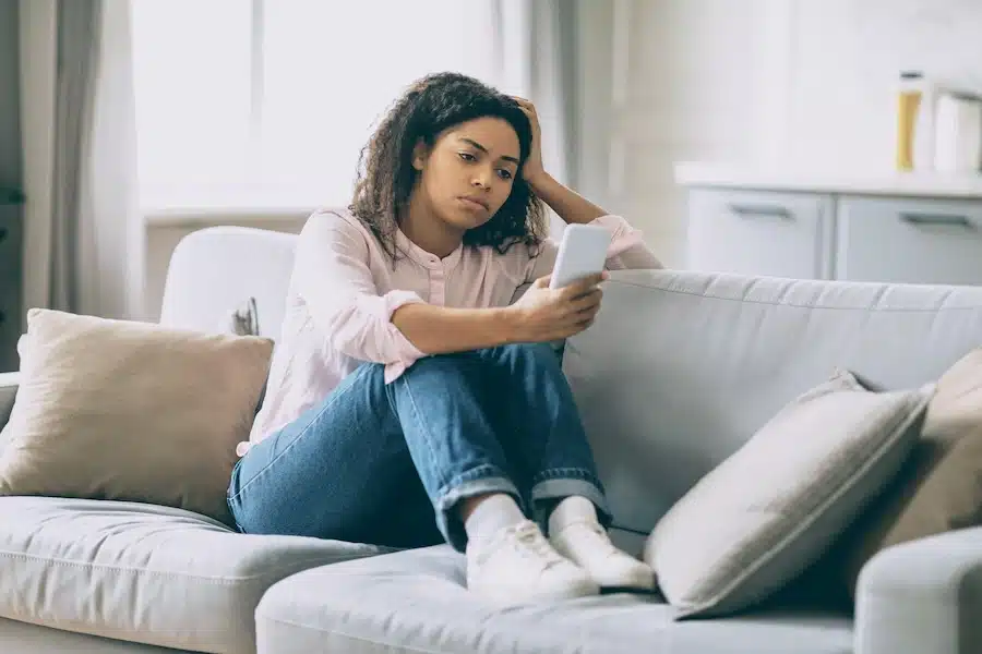 Moderne Coaching-Situation zu Hause: Frau im Video-Coaching mit Zweiweltenkind Life Coaching für Frauen, Blick in die Kamera.