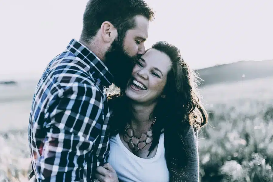 Ein junges Paar umarmt sich liebevoll in der Natur – Symbol für romantische Zweisamkeit im Kontrast zur Frage: "Warum bist ich noch Single?"
