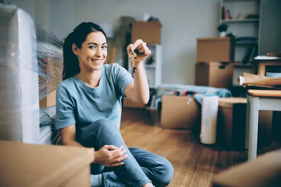 Frau hält Wohnungsschlüssel in der Hand – Symbol für Neubeginn und Mut zur Veränderung